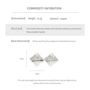 Detail view of 18k gold plated rhombus pattern earring showing 3cm width and copper material