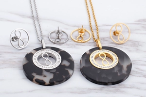 Detail of vintage gold and silver jewelry sets with marble resin and infinity symbols