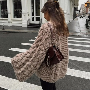 Chunky cable knit sweater with balloon sleeves and a brown leather crossbody bag