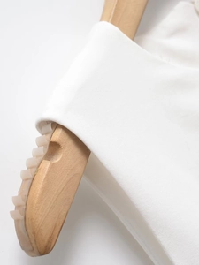 Close-up of high-quality white cotton fabric texture on a wooden hanger with clean details