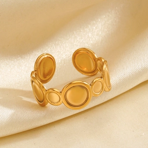 Minimalist geometric gold open ring with stacked circular discs on champagne silk background