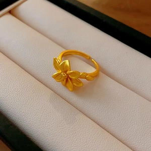 Macro shot of a matte gold flower ring with adjustable band and leaf detail
