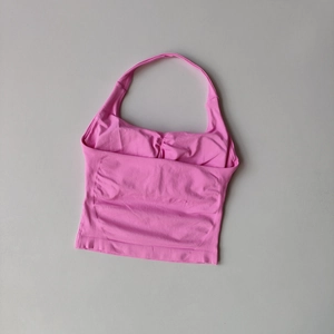 Detailed view of pink square neck sports top featuring ribbed texture and ruched chest design