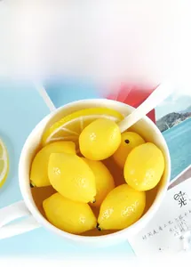 Vista detallada de limones amarillos en miniatura realistas y rodajas en un bol blanco