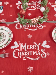 Detail van rood Merry Christmas tafelkleed met witte sneeuwvlokken en feestelijke print