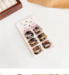 Detailed view of eight leopard print mini hair claws on a fashion display card