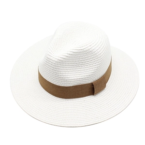 Close-up of white panama straw hat with coffee brown ribbon band and fine woven texture