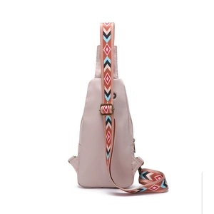 Detail of light pink crossbody bag with a colorful geometric pattern woven strap