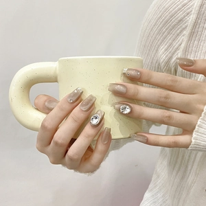 Amber cat eye press-on nails with sparkling rhinestones and silver glitter accents