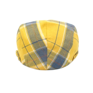 Close-up of yellow plaid newsboy cap with metal side adjustment buckle and texture
