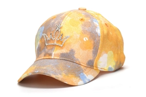 Close-up of sparkling rhinestone crown emblem on colorful tie-dye kids baseball cap