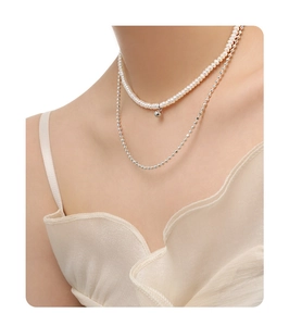 Close-up of double layer sterling silver chain with freshwater pearl and silver ball pendant