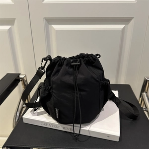 Sac seau minimaliste en nylon noir avec cordon de serrage et poche latérale filet