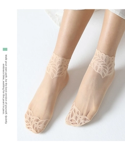 Close-up of sheer skin-tone socks featuring elegant leaf-shaped lace trim on edges