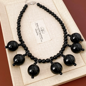 Detail of glossy black acrylic beaded fringe necklace with lobster clasp and chain