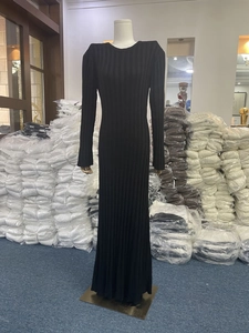 Detail of elegant black long-sleeve knitted maxi dress with vertical ribbed texture