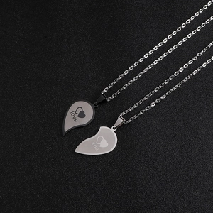 Détail de pendentifs cœur emboîtables pour couples avec gravures Love et You sur métal