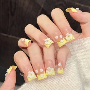 Nude pink and yellow long square press-on nails with 3D white floral and gold accents
