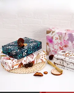 Detail of vintage floral kraft gift wrapping paper on stacked boxes with natural decor
