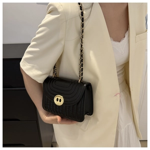 Borsa a tracolla in pelle PU nera trapuntata con dettagli dorati su blazer beige