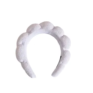 Close-up of white sponge padded headband made of soft terry towel fabric for washing face