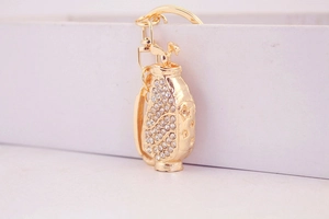 Detailed view of a gold golf bag keychain with sparkling rhinestones on white background
