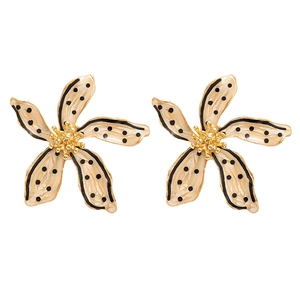 Boucles d'oreilles fleur rétro crème à pois noirs avec bordures dorées sur fond blanc