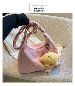 Detail of pink checkered tote bag featuring 3D texture and a yellow star plush charm
