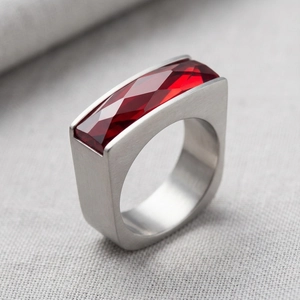 Macro view of a gold stainless steel ring featuring a luxury red square-cut glass gemstone