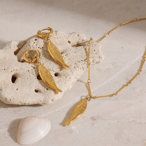 Detail von 18K Gold Fisch-Anhänger Halskette und Ohrringen auf Korallengestein