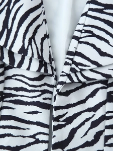 Detail van de zebraprint blazerhals met scherpe revers en twill stofstructuur