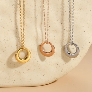Minimalist geometric circular necklaces in gold, rose gold and silver on ceramic background