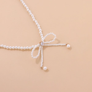Detailed view of elegant pearl bow necklace featuring a central sparkling zircon stone