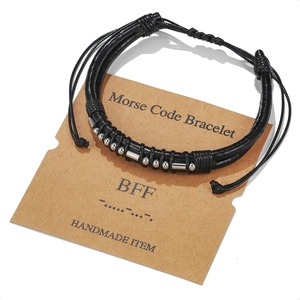 Detail of Morse Code BFF bracelet with black leather cord and silver beads on kraft card