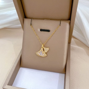 Detail of a ginkgo leaf pendant with sparkling zircons on a gold-plated titanium chain