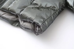 Detailed macro view of the adjustable drawstring hem on this metallic grey puffer jacket