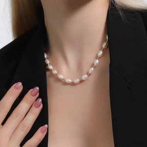 Elegant natural freshwater pearl necklace with gold beads on model wearing black suit