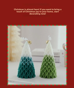 Detailed view of two Christmas tree candles with snow-covered tips and golden bells