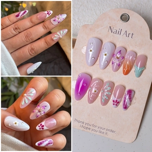Detail of 3D embossed floral almond press-on nails with pearls and pink gradient design