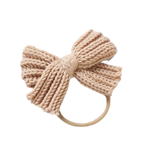Soft beige knit bow baby headband with elastic nylon band for newborns and infants