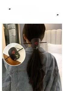 Détail de l'épingle à cheveux en cuir avec imprimé rose rouge et style rétro chic