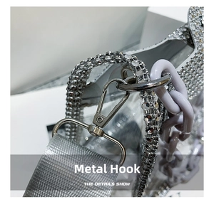 Detail of transparent PVC bag with silver rhinestone edges and purple chunky chain strap