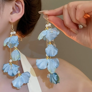Détail des boucles d'oreilles fleurs en soie bleue avec perles blanches et or fin