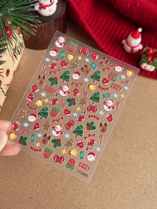 Macro view of 5D embossed Christmas nail art stickers featuring Santa and tree patterns