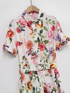 Détail d'une robe midi fleurie en popeline avec col chemise, manches courtes et ceinture