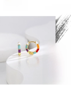 Detailed view of colorful enamel bamboo hoop earrings on a minimalist white platform