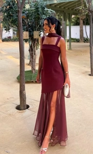 Macro detail of the sheer mesh slit hem on an elegant burgundy backless maxi dress