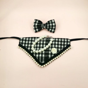 Detail of houndstooth pet bandana set with bow tie and elegant pearl necklace