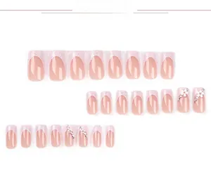 Detail of 24pcs pink French press-on nails with 3D white flowers and sparkling rhinestones
