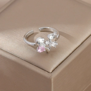 Macro shot of silver open ring with double hearts and pink zircon on metallic box